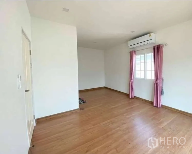 Detached House for sale in Bang Khen, Bangkok - Upper-floor bedroom with wood flooring, air conditioner and pink curtains.