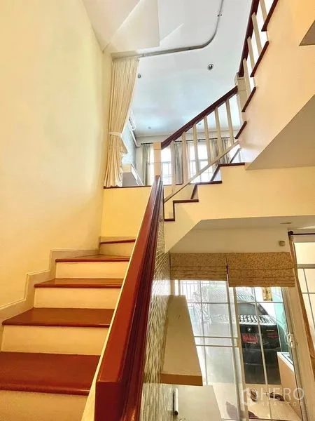 Townhouse for rent in Saphan Sung, Bangkok - Staircase with wooden treads and white balustrade connecting the townhouse’s split levels.