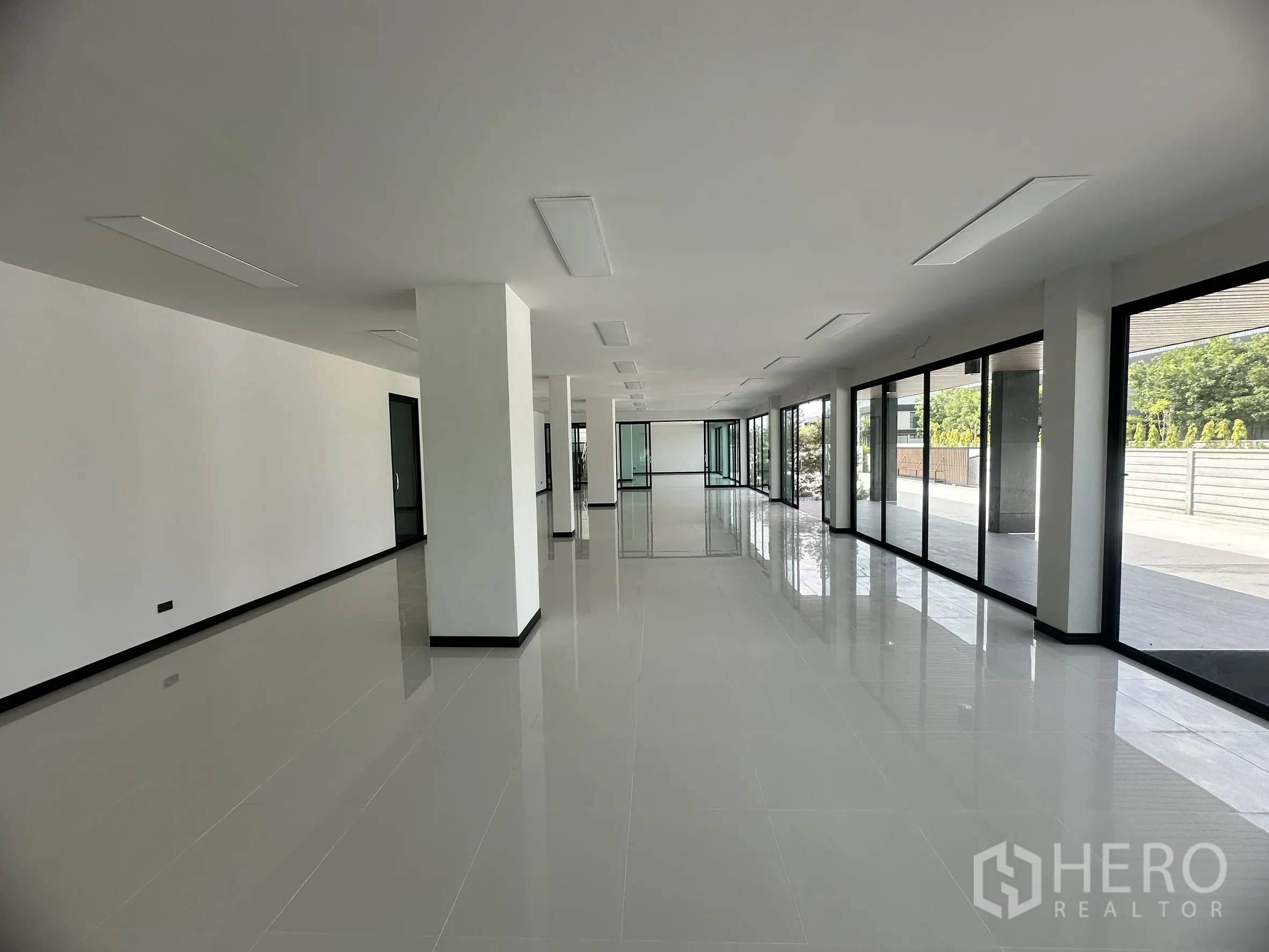 工厂 for rent or sale in Bang Len, Nakhon Pathom - 明亮的办公内部，白色瓷砖地面与玻璃隔断、落地窗。