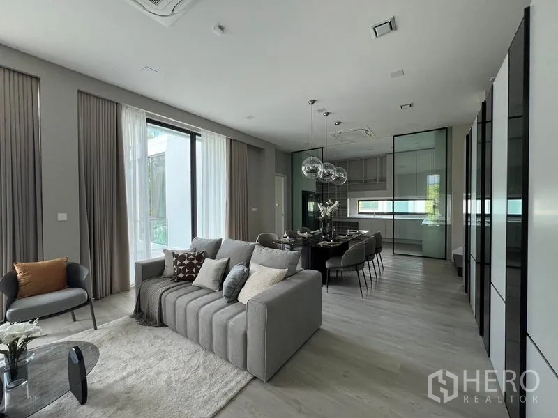 Detached House for rent in Saphan Sung, Bangkok - Open-plan living, dining and modern kitchen with glass partitions and pendant lights.