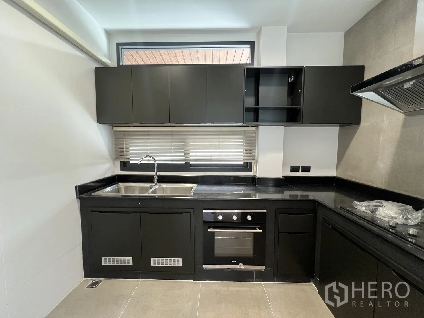 Detached House for rent in Saphan Sung, Bangkok - Kitchen with double stainless sinks, wall cabinets and window blinds for natural light control.
