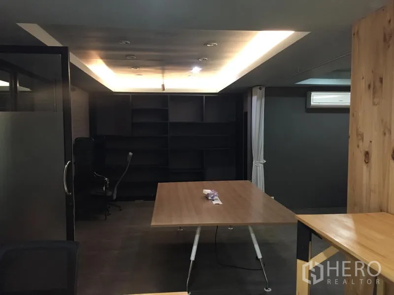 办公空间 出租在Khlong Toei, Bangkok - 会议室，吊顶嵌灯、木质会议桌与深色内置书架