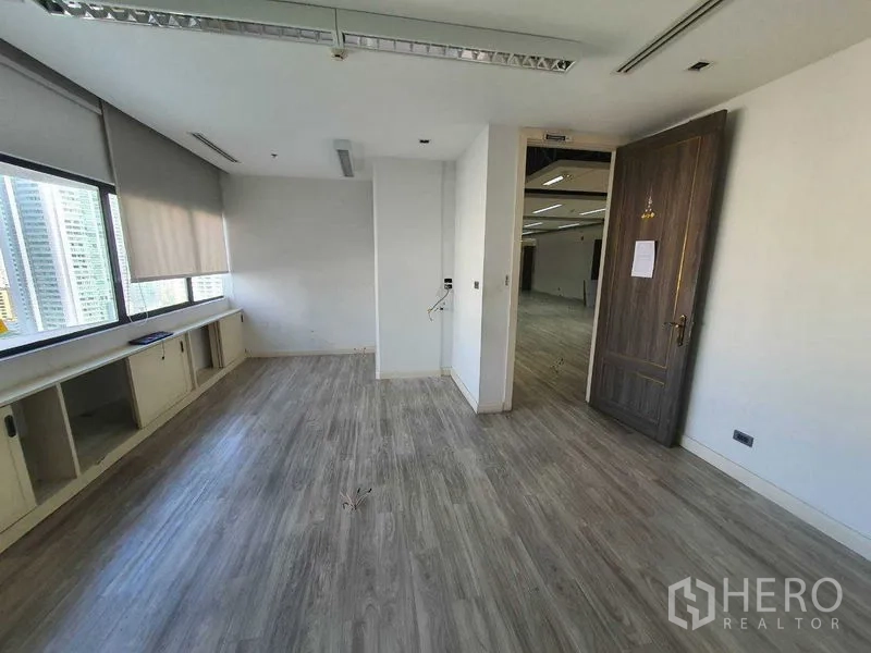 Office Space for rent in Watthana, Bangkok - Private workspace with light wood flooring and a large window.
