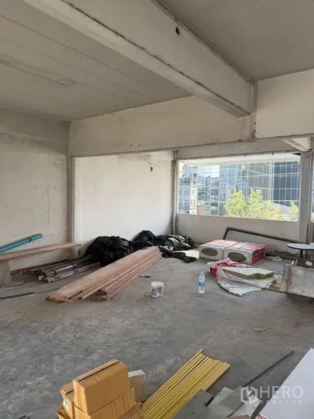 Shophouse for rent in Watthana, Bangkok - Bright interior with wide windows and raw concrete, ideal for office or showroom fit-out.