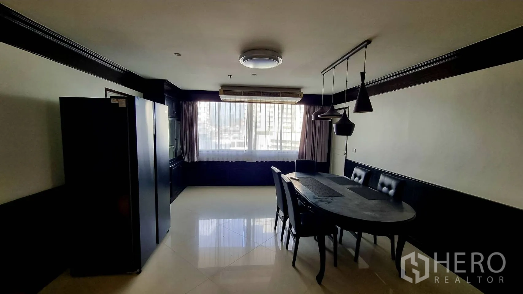 Condominium for rent in Watthana, Bangkok - Bright dining area with pendant lights and a large window beside the fridge.