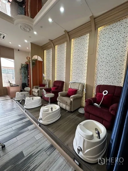 Retail Space for rent in Khlong Toei, Bangkok - Row of pedicure chairs on a raised platform with individual foot spa basins and warm accent lighting.