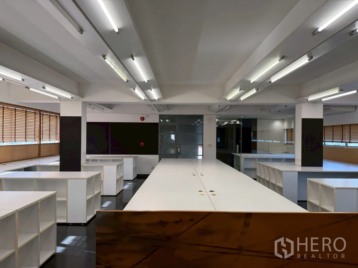 办公室 for rent in Huai Khwang, Bangkok - 开放式办公室，白色长工作台、日光灯、玻璃隔间与内置收纳。