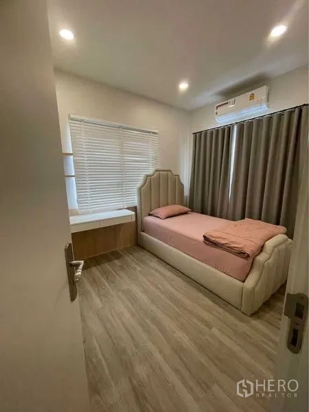 独立式住宅 出售在Lat Krabang, Bangkok - 紧凑卧室，单人床、书桌与百叶窗窗帘。