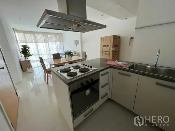 Condominium for rent in Watthana, Bangkok - U-shaped kitchen featuring electric stove, oven, sink, and stainless-steel hood.