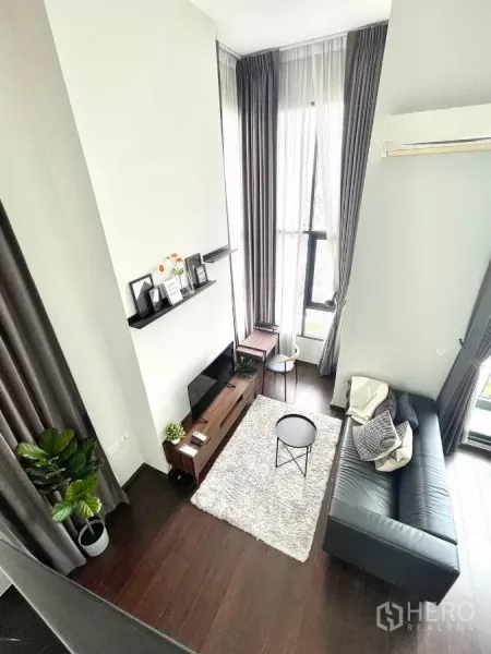 คอนโด ให้เช่าในWatthana, Bangkok - ห้องนั่งเล่นสไตล์ลอฟต์ เพดานสูง พื้นไม้เข้ม และหน้าต่างสูงจรดเพดาน
