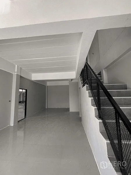 货栈 出租在Bang Pakong, Chachoengsao - 一层门厅地砖光亮，金属扶手楼梯通往夹层。