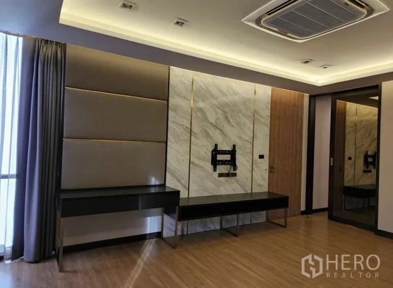 Townhouse for sale in Yan Nawa, Bangkok - Master bedroom feature wall with TV mount, desk and ceiling lighting.