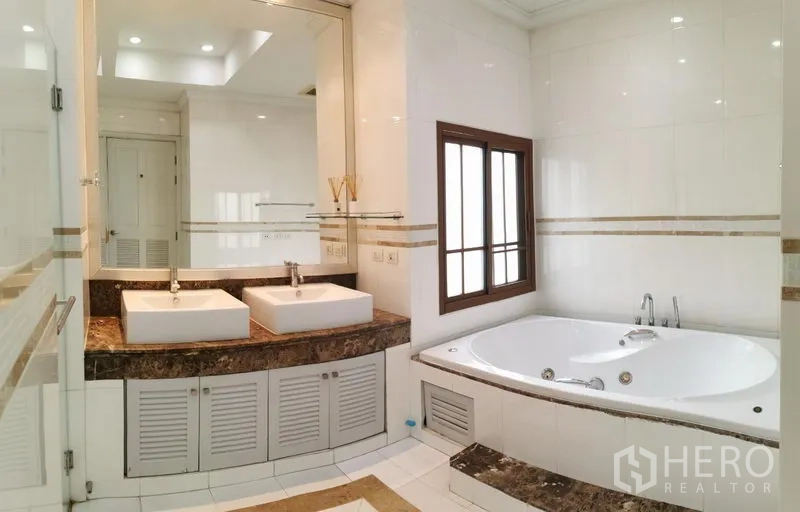 บ้าน ให้เช่าในWatthana, Bangkok - ห้องน้ำหลักมีอ่างล้างคู่ เคาน์เตอร์หิน และอ่างอาบน้ำบิลต์อินติดหน้าต่าง