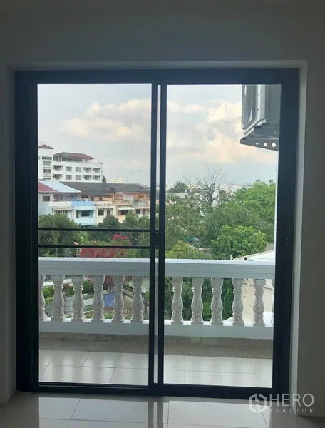 带办公室的家 出租在Khlong Toei, Bangkok - 透过推拉门可见带栏杆的小阳台与绿树及低层社区景观。