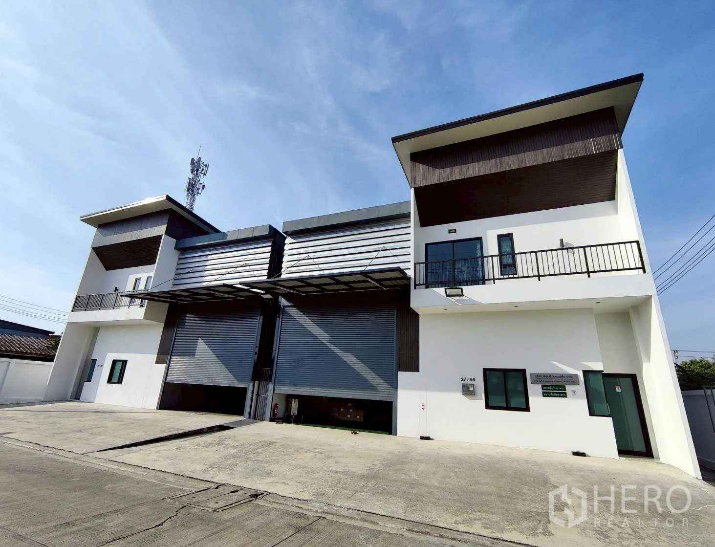 Warehouse for rent in Lam Luk Ka, Pathum Thani - Angled exterior of the warehouse complex with covered canopies and concrete road access.