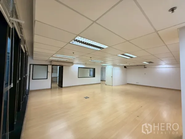 Office Space for rent in Watthana, Bangkok - Large open-plan office with drop ceiling lights, light wood flooring and internal windows.