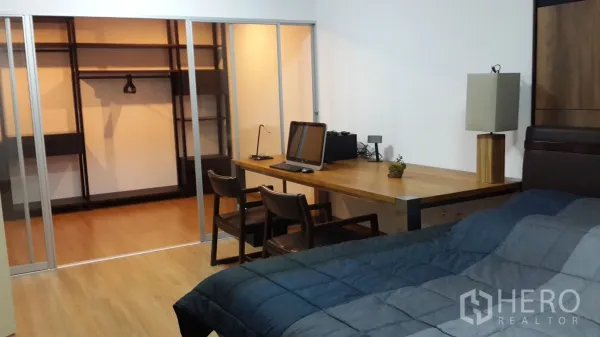 公寓 出租在Huai Khwang, Bangkok - 卧室配被褥与长木制书桌，通过滑动隔断进入步入式衣帽间