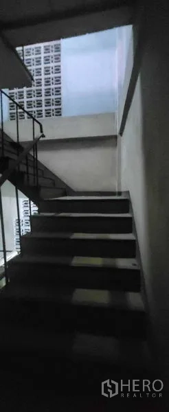 Shophouse for rent in Khlong Toei, Bangkok - Concrete stairwell with metal handrail connecting the upper floors of the shophouse.