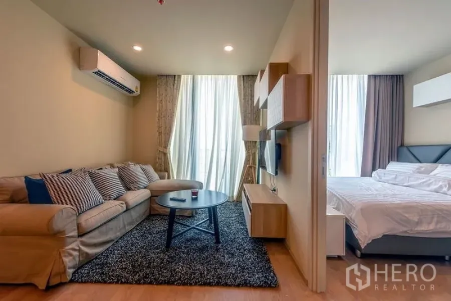 公寓 出租在Watthana, Bangkok - 客厅通过推拉门与卧室相连，明亮窗帘与舒适沙发。